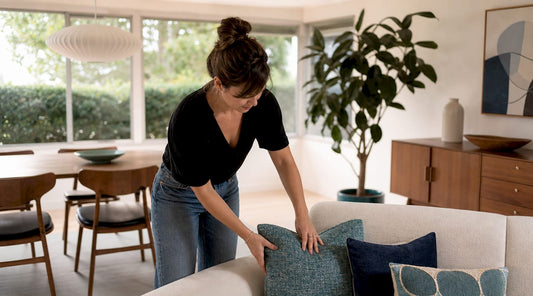 Woman arranging cushions in mid-century modern living room